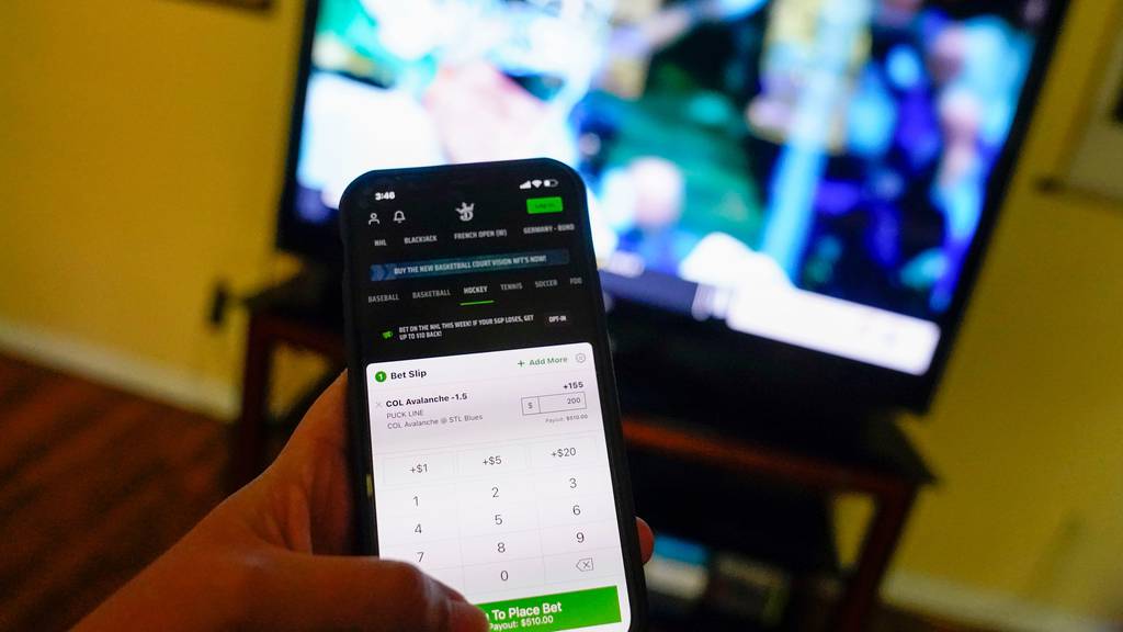 DraftKings app in hand infront of TV